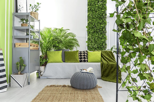 This botanical living room with grey sofa, green pillows and bookcase is on trend.