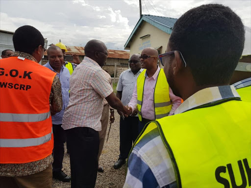 Water CS Simon Chelugui arriving at the Likoni Water Project site on Friday. He is welcomed by contractor, Suhufi Agencies Ltd director Siyad Issak. /CHARLES MGHENYI