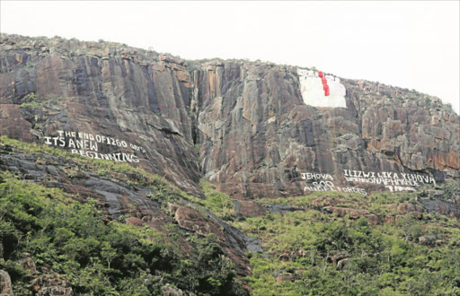 WRITING’S ON THE WALL: Cryptic words are written on the side of a mountain behind the Mancoba Seven Angels Ministries at Nyanga village near Ngcobo, with a rendition of seven angels above Picture: LULAMILE FENI