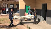 A screen shot from a video showing the body of one of the security guards being carried out of a classroom at Ukusa High School, west of Durban