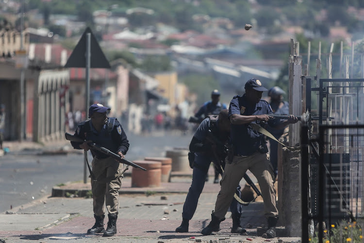 Police fire rubber bullets while being pelted by rocks by protesters, in October 2018, in Westbury, Johannesburg.