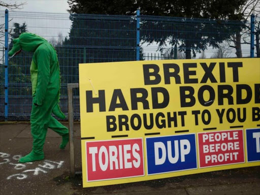 A man dressed as a Crocodile walks past a sign about Brexit in West Belfast, Northern Ireland March 2, 2017. /REUTERS