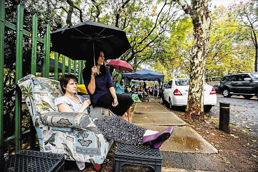 FOR THE KIDS: Anita Brand and Sally Wrench queuing to apply for the admission of their children to Grade R at Parkview Junior Primary School. Parents and their domestic workers camped outside the school in the rain even though registration opens only today