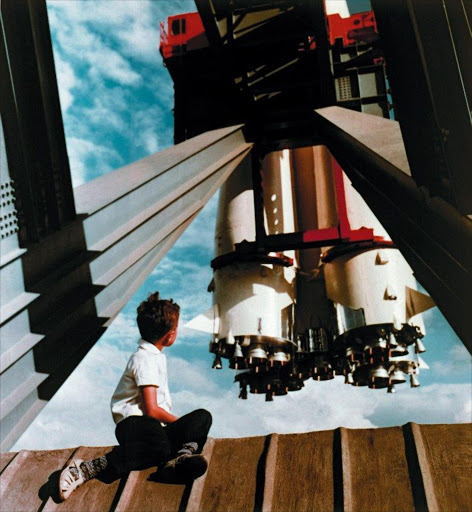 A picture taken in Moscow on July 19, 1967 shows a young visitor to the National Exhibition of Economic Achievements sitting near the Space pavilion watching a model of the Vostok launch vehicle on board of which Yury Gagarin left into space being the first human to orbit the earth on April 12, 1961.