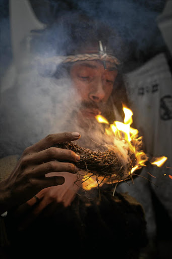 MORNING ROAST: /Ae /Uib Khomkhoeb Klintin Whitehead burns a bundle of impepho in a prayer ceremony in Pearston, Eastern Cape. Before the team departed each morning, the walkers held a ceremony where they sang in Nama and said a prayer for a safe journey.