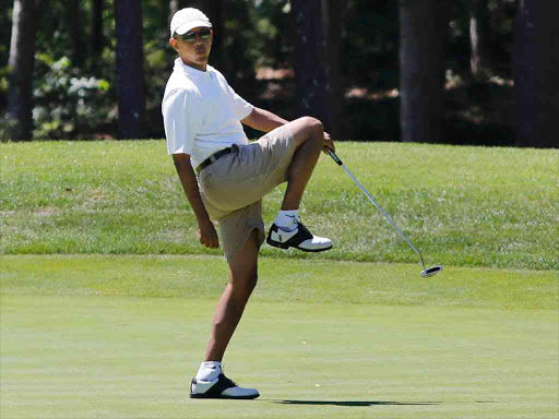 US President Barack Obama reacts after missing a putt on the first green at the Farm Neck Golf Club at Oak Bluffs on Marthas Vineyard, August 11, 2013. /REUTERS