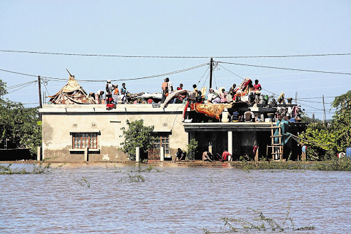 Residents seek refuge on rooftops to escape the flood waters in Chokwe, Mozambique Picture: FERHAT MOMAD