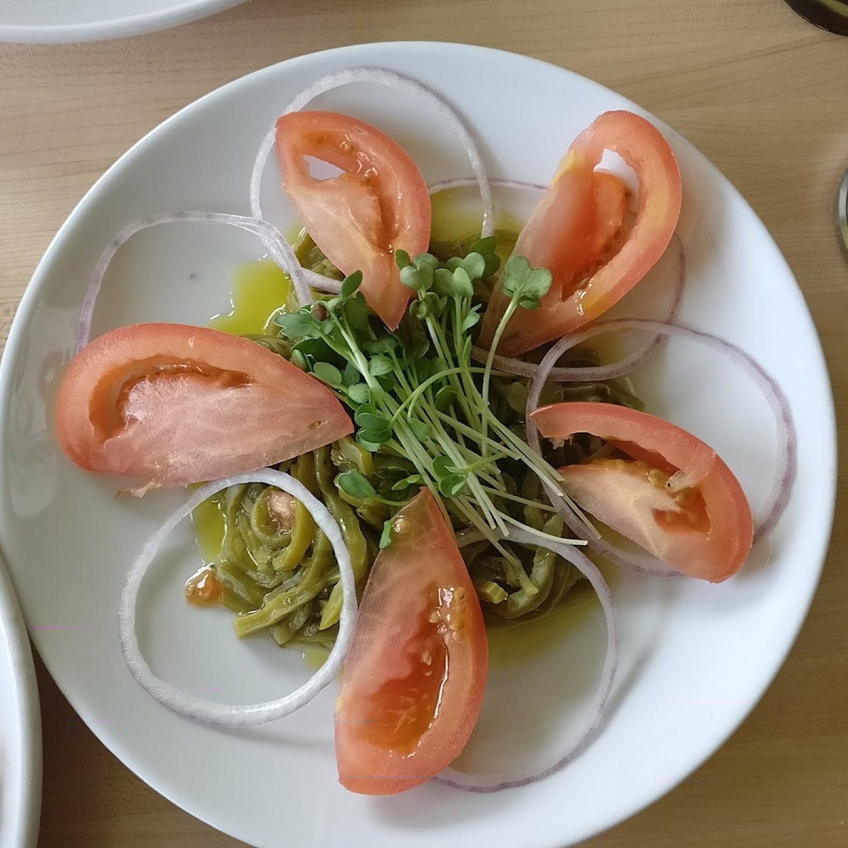 This is the Cactus appetizer with tomatoes and onions and pea shoots that I asked them to leave off the cheese.