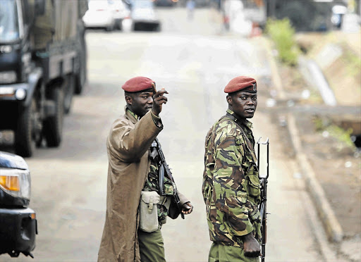 URBAN FRONTLINE: Kenyan soldiers outside the Westgate Mall in Nairobi yesterday, the fourth day of a siege by Islamist terrorists in which more than 70 people were killed.