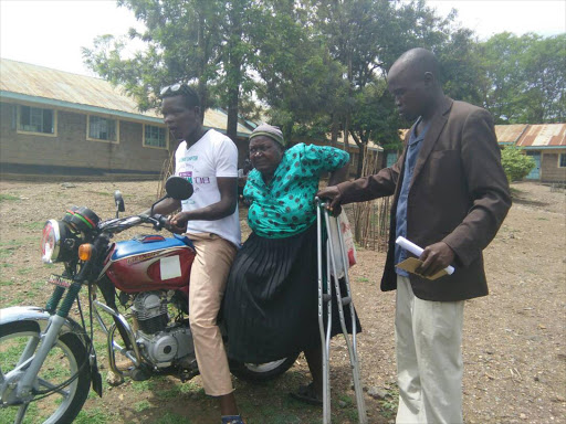 An elderly woman is assisted to get off a motorbike when she arrived to cast her vote at a polling station in Homa Bay, April 24, 2017. /ROBERT OMOLLO