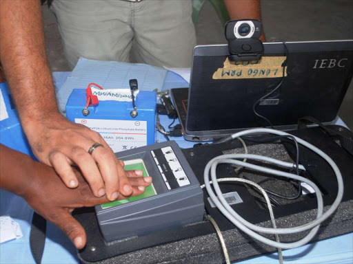 A voter has her fingerprints taken by an IEBC clerk at Makadara Grounds, Mombasa during the ongoing mass registration. /ANDREW KASUKU