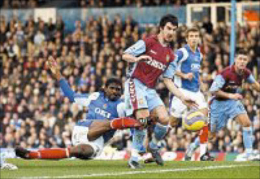 FLASHBACK: Portsmouth's Nwankwo Kanu, left, goes close despite the attention of Aston Villa's Liam Ridgewell. © Unknown.