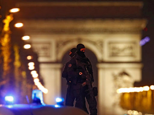 Masked police stand on top of their vehicle on the Champs Elysees Avenue after a policeman was killed and two others were wounded in a shooting incident in Paris, France, April 20, 2017. /REUTERS
