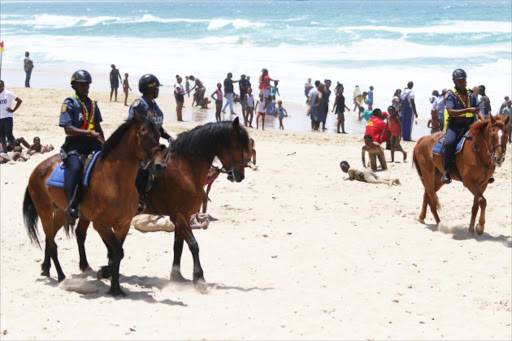 SADDLED FOR SAFETY: As part of the festive season's control measures, the SAP's mounted unit patrol the Eastern Beach in East London. Picture: MICHAEL PINYANA