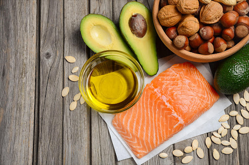 There is no food containing fat which doesn't contain all three types of fat; saturated, mono-unsaturated and polyunsaturated. Salmon, for instance, has around 3.5 grams saturated fat per 100g.