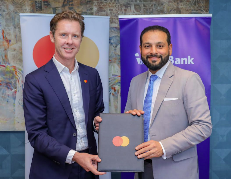 Mastercard president for Africa Mark Elliott with I&M Bank COE Gul Khan hold the framework agreement which will extend their strategic collaboration/HANDOUT