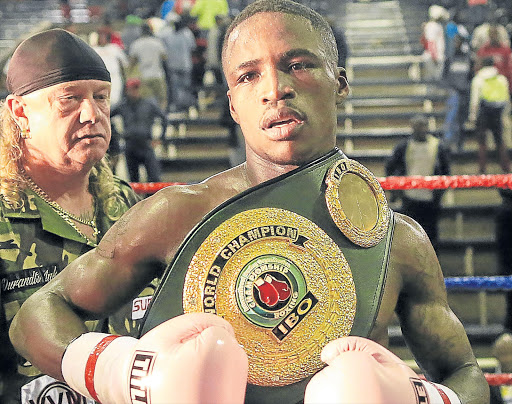 TIGHTEN YOUR BELT: Lusanda Komanisi with his IBO world featherweight title spoils after he beat Roli Gasca of the Philippines at the Orient Theatre on Friday night Picture: STEPHANIE LLOYD