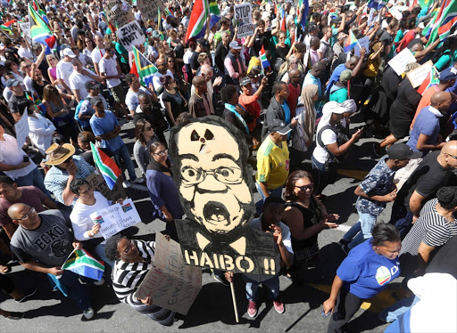 Demonstrators in Cape Town gather around a huge Zuma-nuclear mask. There are fears that President Jacob Zuma will agree to lavish spending on nuclear power stations which were opposed by his sacked finance minister.