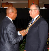 Speaker Jonathan Lawack places the mayoral chain around Athol Trollip’s neck to symbolise his election as mayor. Reader Marion Harning comments: ‘In a massive tribute to returning to colonialism, and a put-down to all colonised peoples, Athol Trollip chose to be inaugurated with a gold mayoral chain.’ Pic: Brian Witbooi.