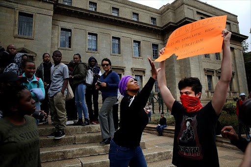 OCTOBER 4 , 2016.LONE VOICE: Student Stuart Young holds a placard that expresses his wish to resume classes, while another student tries to snatch it away . Pic. Alon Skuy. © The Times. Fees Must Fall. The planned shut-down at the University of the Witwatersrand on Tuesday started off peacefully with a heavy police presence, but stun grenades and tear gas have been used to disperse gathered students, some of whom have been detained. Protests also continue on other campuses.Students and police clashed as Wits University reopened its doors on Tuesday.