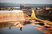 Member of the task force on illegal crude oil bunkering and artisanal refinery stand around a dug crude storage facility during the destruction of Bakana ii camp in Okrika, Nigeria January 28 2022. File photo.