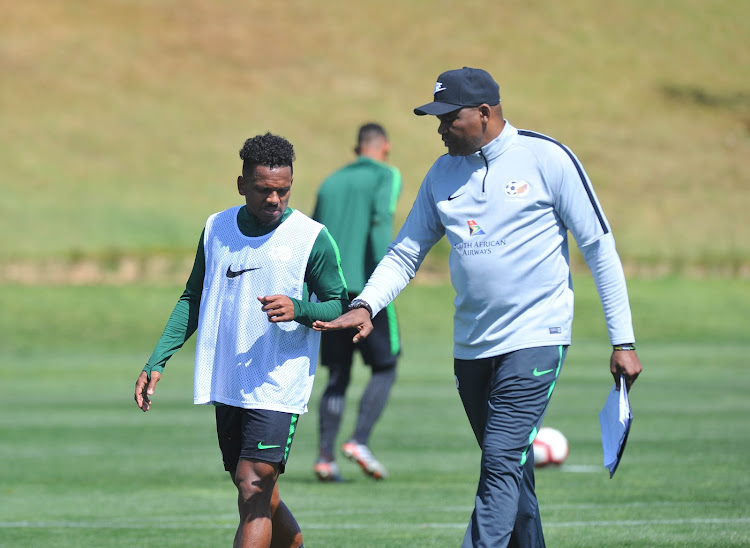 Bafana Bafana striker Kermit Erasmus listens carefully as head coach Molefi Ntseki talks to him during a training session .