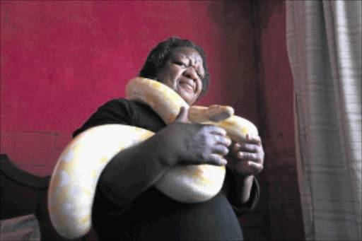 WRAPPED UP: Lindiwe Mngomezulu with one of the exotic snakes she keeps caged at her home in Orlando West, Soweto PHOTO: ALON SKUY