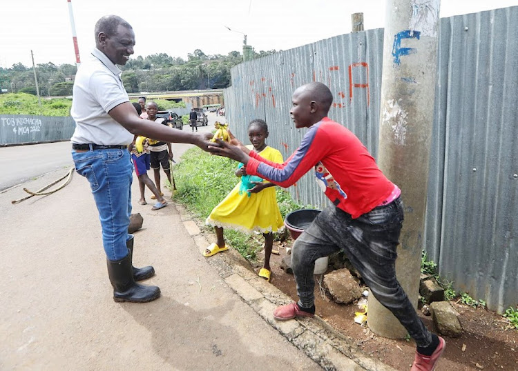 President William Ruto distributes bananas to residents in Mathare when he visited the area to assess flood situation on May 6, 2024. DENIS ITUMBI / FACEBOOK