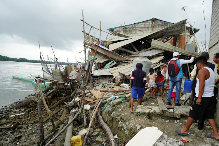 People look at a destroyed house following an earthquake in Isla Puna, Ecuador, March 19 2023. Picture: MARIA FERNANDA LANDIN/REUTERS