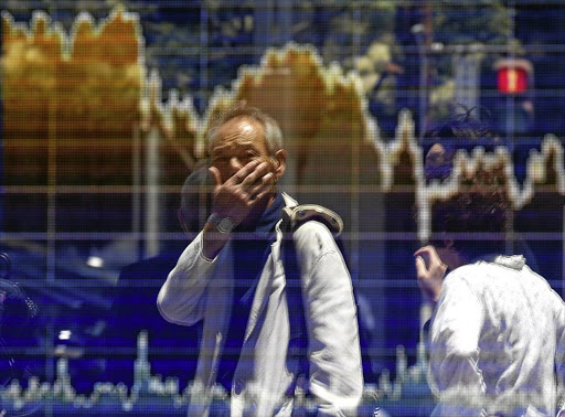 A man tracks the ups and downs of the market in the window of a Tokyo brokerage.