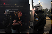 SENSITIVE MATERIAL. THIS IMAGE MAY OFFEND OR DISTURB An injured woman shouts at a riot police officer as people protesting against coronavirus disease vaccinations clash with police, during the annual speech of Greek Prime Minister Kyriakos Mitsotakis on the state of the country's economy, in Thessaloniki, Greece on September 11 2021. 
