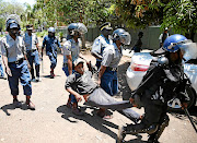 Zimbabwean police carry a protester during a march on government offices in Harare in 2019. The country's government has been criticised in a report by Amnesty International for its nationality laws which have seen thousands of its citizens rendered stateless. File photo.