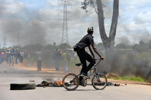 A child among the protests on February 4, 2014, in Bronkhosrtspruit, South Africa. Locals from Zithobeni continued their service delivery protests in Bronkhorstspruit. They barricaded roads with tyres, causing the situation to become the most tense it has been all week.