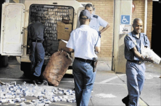 GOING UP IN SMOKE: Police confiscate illegal cigarettes with a street value of R100000 in Polokwane, Limpopo. The Tobacco Institute of Southern Africa has called on South Africans to help fight the scourge of illicit trade which is estimated to have cost the country more than R20-billion in tax revenue since 2010 Photo: ELIJAR MUSHIANA