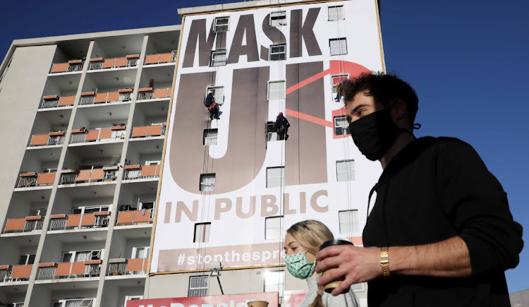 Workers put the finishing touches to a Covid-19 message encouraging Capetonians to wear masks, on a building on the corner of Buitensingel and Long streets.