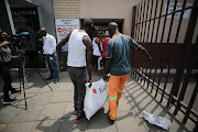 Customers queue to return meat to the Enterprise factory store in Germiston, east of Johannesburg, on March 5 2018.