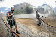 HOSE WERE THE DAYS: Capetonians help firefighters to try to save their homes from a raging blaze in Tokai