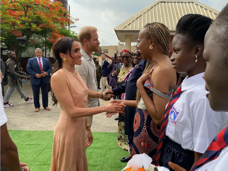 The Duke and Duchess of Sussex greeting people at the Lightway Academy in Abuja