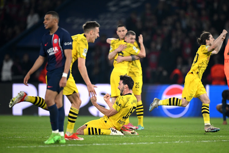 Kylian Mbappé of Paris St-Germain looks dejected as goal-scorer Mats Hummels of Borussia Dortmund celebrates victory with teammates after winning the Uefa Champions League semifinal in the second leg match at Parc des Princes in Paris on Tuesday night.