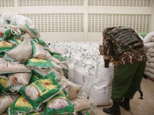 FAKES: A security officer guards seized counterfeit and mislabelled goods at the Export Processing Zone in Miritini, Mombasa, yesterday.