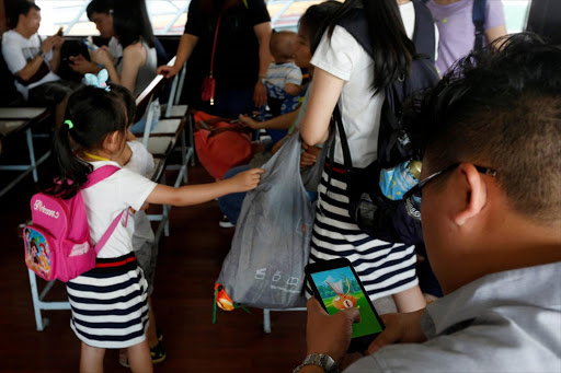 A passenger plays "Pokemon Go" on a ferry after the augmented reality mobile game launched in the city in Hong Kong, China, July 26, 2016. Picture Credit: REUTERS/Bobby Yip