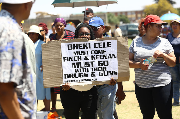A community member of Westbury shows off her placard during a meeting with Minister Bheki Cele, on October 2 2018 after the police clashed with the community on October 1 2018