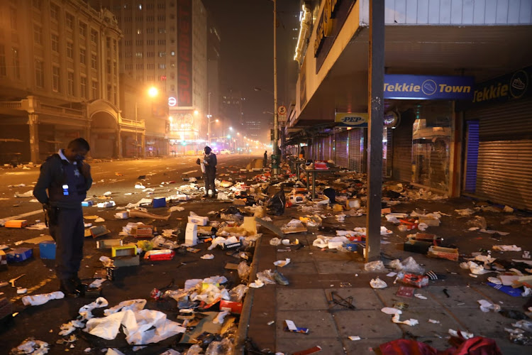 A police officer inspects the aftermath of rioting and looting in KZN. File photo.