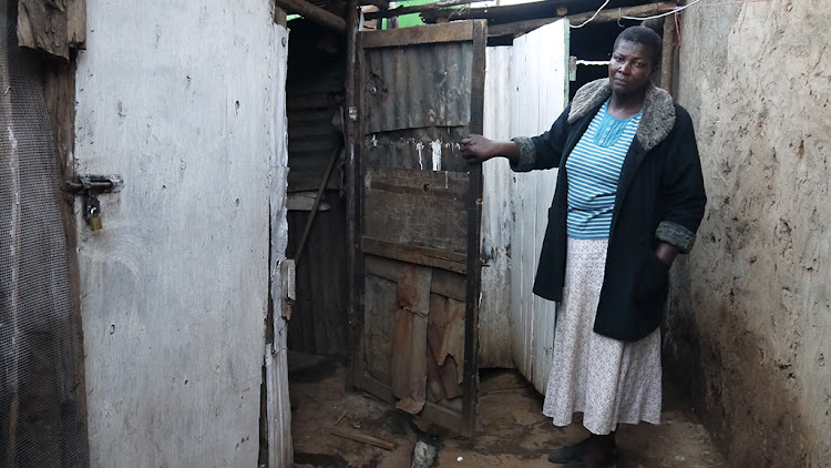 Mama Roseline Amondi at an old pit latrine.