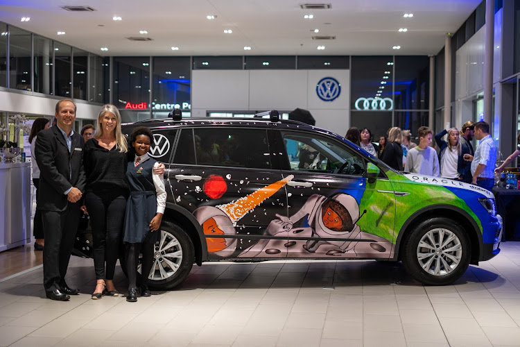 PROUD WINNER: Buchule Maseti of Erica Primary had her design detailed on the Volkswagen Allspace. With her are Martin Taverner of Tavcor and Lisa Hundleby