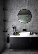 The home's moody colour palette is carried through into the master bathroom.