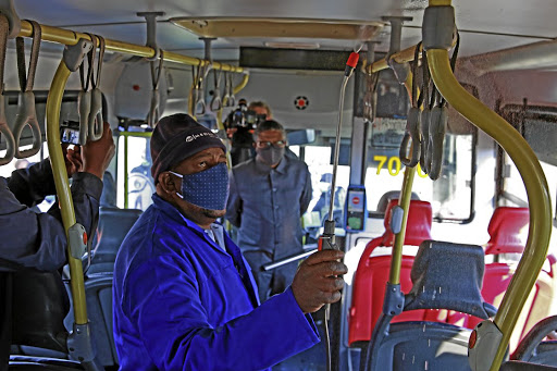 Shadrack Mphailane shows transport minister Fikile Mbalula how he disinfects a Rea Vaya bus in Johannesburg. The minister, who was on a tour of public transport in the city, said he was satisfied with the measures taken by the bus service to prevent the spread of the coronavirus among passengers.