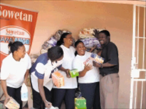 THANKFUL: Staff of the Family Worship Hospice in Westbury, Johannesburg, with some of the gifts. © Sowetan.