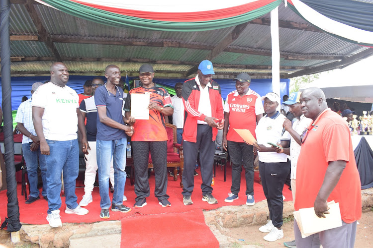 Busia Governor Paul Otuoma and KVF President Charles Nyaberi present certificate to some of the coaches who completed training in Busia on Sunday.