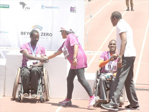WELL DONE: Margaret and Uhuru congratulate two of the disabled people who participated in the marathon. Photo/File